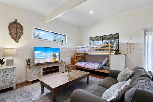 a living room with a couch and a bunk bed at Bluelake Cottage Metung in Metung