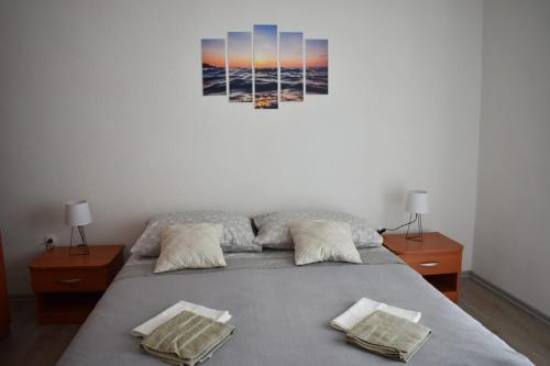 a bedroom with a bed with two night stands and a painting on the wall at Apartment Doris - entire floor & sea view in Gradac