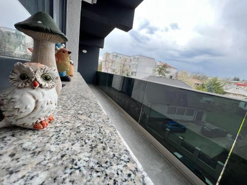 an owl figurine sitting on a ledge next to a window at City Center Sunny Apartment in Suceava