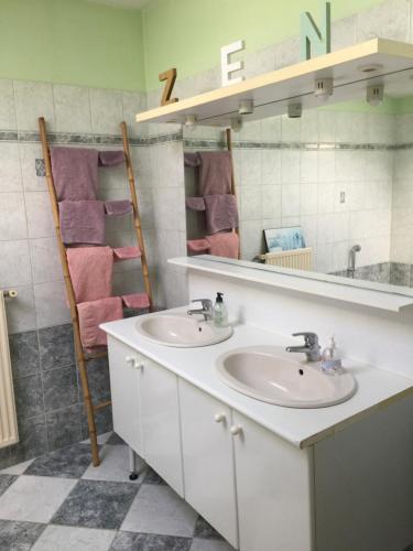 La salle de bains est pourvue de 2 lavabos et d'un miroir. dans l'établissement Belle longere 130 m2 aux portes du marais poitevin, à Niort