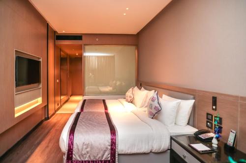 a hotel room with a bed and a television at Regenta Place Verka Amritsar in Amritsar