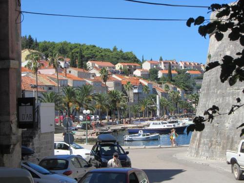 a city street with cars and a harbor with boats at Guesthouse Franica in Korčula