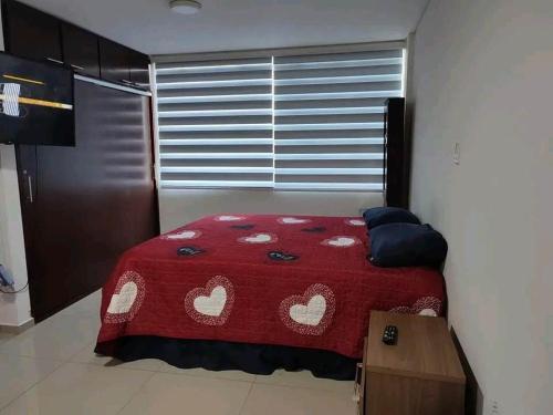 una camera da letto con un letto rosso con dei cuori sopra di Edificio Baruc Norte Monoambiente a Santa Cruz de la Sierra