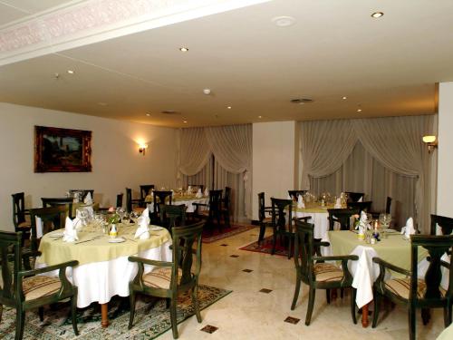 a restaurant with tables and chairs in a room at Ramada By Wyndham Fes in Fès