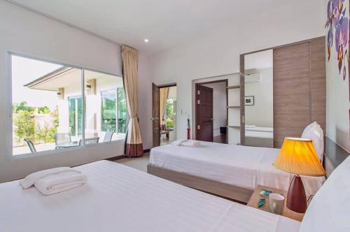 En eller flere senge i et værelse på Private Pool Villa at Nai Harn 2 bedroom