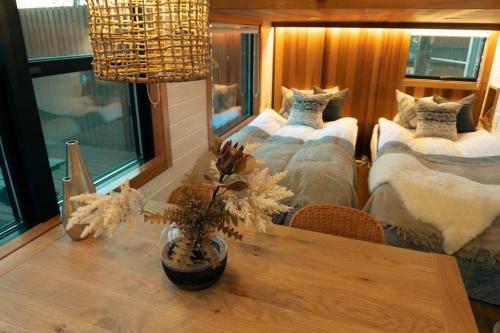 a room with three beds and a table with flowers at サウナバーベキュージャグジー完全貸し切りという贅沢大人の秘密基地#01 in Miyota