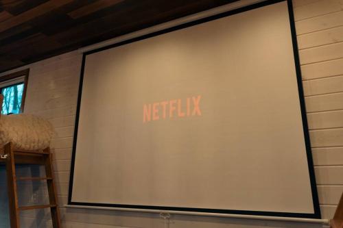 a big screen television on a brick wall at サウナバーベキュージャグジー完全貸し切りという贅沢大人の秘密基地#01 in Miyota