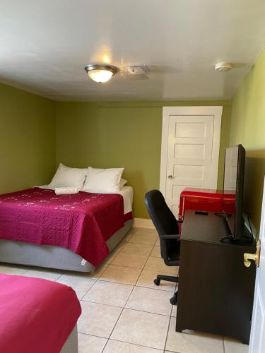 a bedroom with a bed and a desk and a television at Spacious Private Los Angeles Bedroom with AC & WIFI & Private Fridge near USC the Coliseum Exposition Park BMO Stadium University of Southern California in Los Angeles