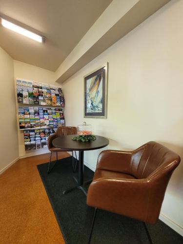 a waiting room with a table and a leather chair at City of Sails Motel in Auckland