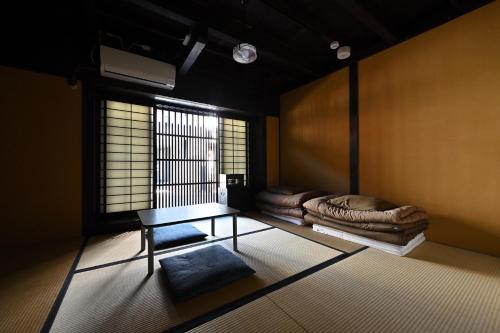 een kamer met een tafel, een bed en een raam bij Teahouse Rouji in Kyoto