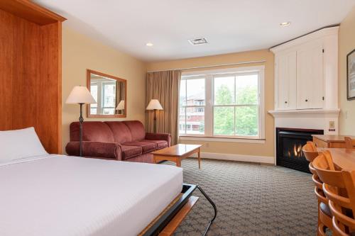 um quarto de hotel com uma cama e uma lareira em Jackson Gore Village on Okemo Mountain em Ludlow
