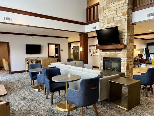 a lobby with a couch and chairs and a fireplace at Staybridge Suites Milwaukee West-Oconomowoc by IHG in Oconomowoc