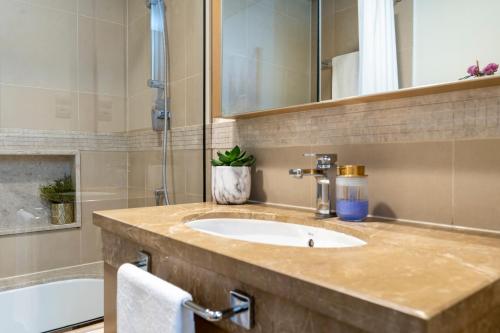 a bathroom with a sink and a bath tub at Prestige Living 1BR with Full Burj Khalifa View by Auberge in Dubai