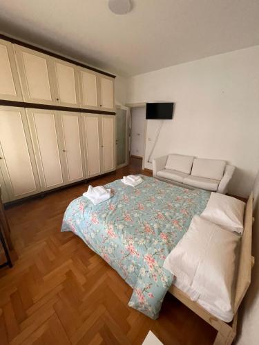 een slaapkamer met een bed en een bank erin bij La casa di Chicco in Trieste
