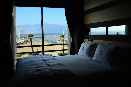 a bedroom with a bed with a view of a beach at Burhaniye Marina Boutique Hotel in Burhaniye