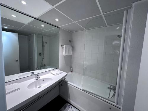 La salle de bains est pourvue d'un lavabo, d'une douche et d'un miroir. dans l'établissement Accès direct à Paris - Studio confort, à Pantin
