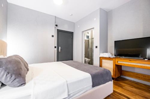 a bedroom with a bed and a flat screen tv at Hotel Centro Bodrum in Bodrum City