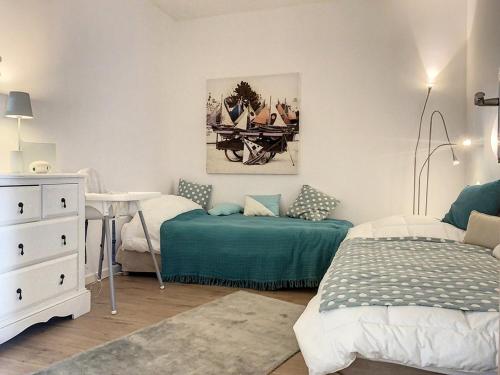 a bedroom with two beds and a table and a bedskirts at Appartement Cucq-Stella Plage, 3 pièces, 4 personnes - FR-1-236-149 in Cucq