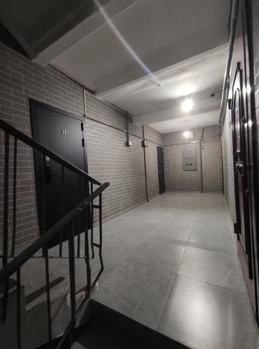 an empty room with a staircase and a brick wall at 2-комн на Молдагулова in Shymkent