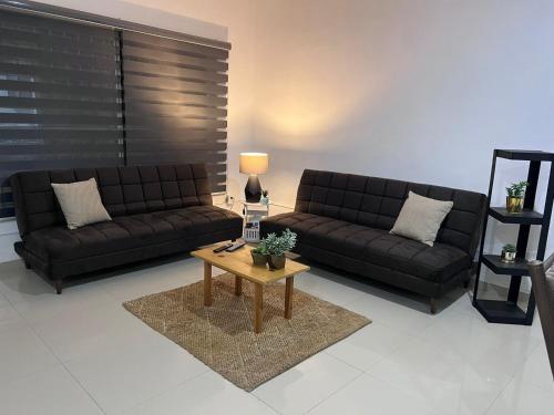 a living room with two black couches and a coffee table at TWO bedroom apartment 101 in Mazatlán