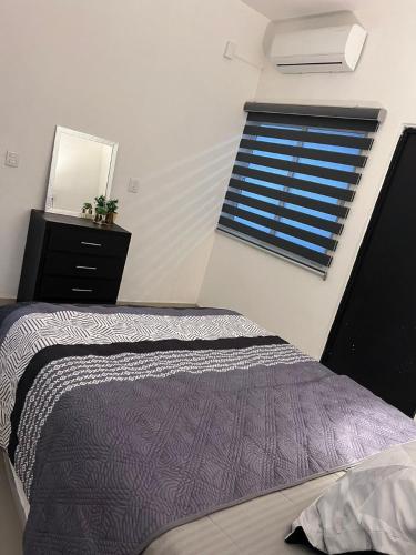 a bedroom with a window with a bed and a dresser at TWO bedroom apartment 101 in Mazatlán