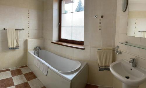 a bathroom with a bath tub and a sink at Hotel Ostrov Garni in Sadská