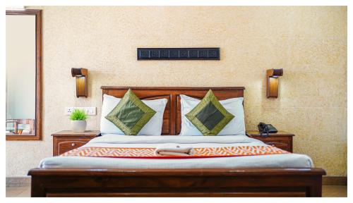 Cama con cabecero de madera y almohadas en Hotel Mart View en Kochi