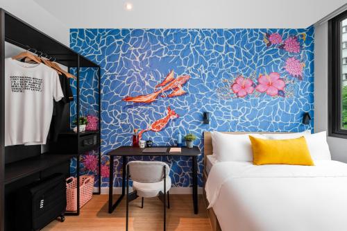 a bedroom with a blue wall with a bed and a desk at lyf Chinatown Kuala Lumpur in Kuala Lumpur