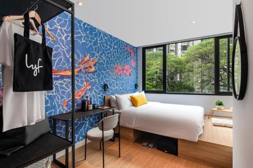 lyf Chinatown Kuala Lumpur في كوالالمبور: غرفة نوم بسرير وجدار ازرق