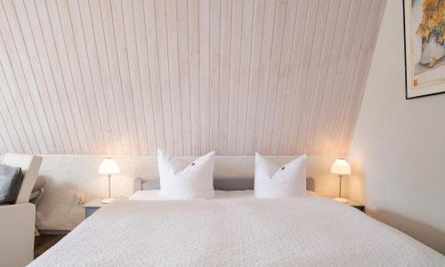 ein Schlafzimmer mit einem großen weißen Bett mit zwei Lampen in der Unterkunft Sonnenblumenhaus 02 in Prerow