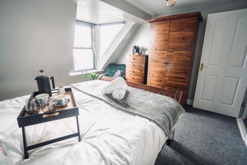 Un dormitorio con una cama grande y una mesa. en Modern Penthouse Apartment in Cobh Town, en Cobh