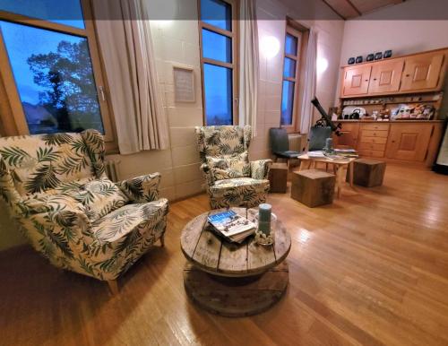 a living room with two chairs and a coffee table at BnB SchlafSchloss in Sumiswald