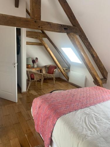 a bedroom with a bed and a table in a attic at Un bijou au cœur de Belleme in Bellême
