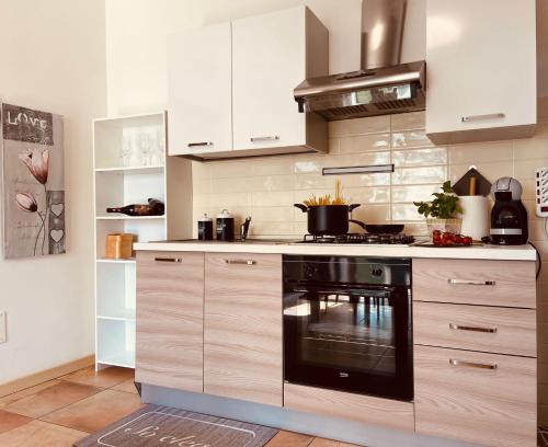 a kitchen with white cabinets and a black oven at Green Park Apartment in Cavaion Veronese