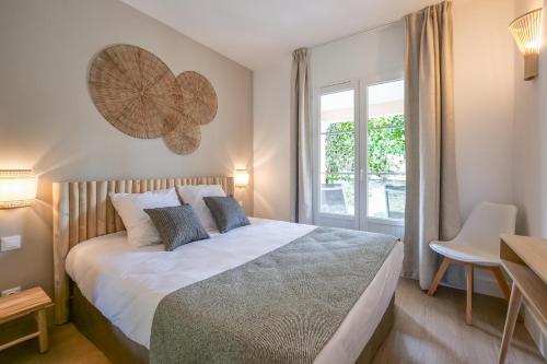 une chambre avec un grand lit et une fenêtre dans l'établissement Rêves de Provence proche plage et Saint Tropez 1, à Saint-Tropez