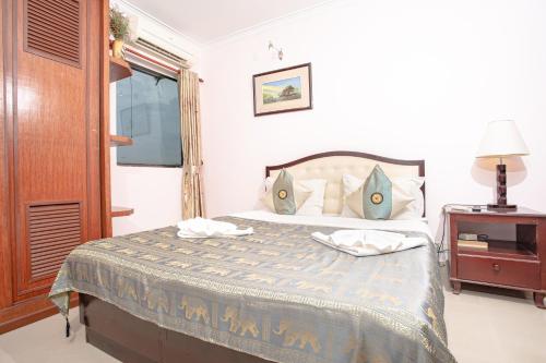 a bedroom with a bed and a table with a lamp at Silver Mounts Hotel in Phnom Penh