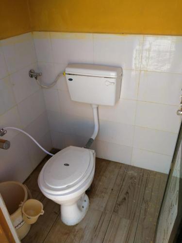 W pokoju znajduje się łazienka z białą toaletą. w obiekcie Patel's Home w mieście Bhuj
