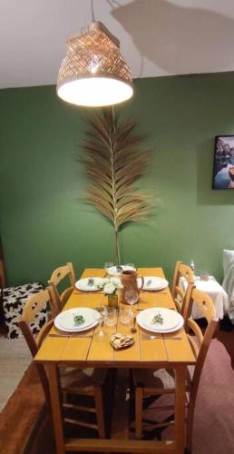 une table en bois avec des plaques et une plante sur celle-ci dans l'établissement Appartement cosy cœur de station, à Villard-de-Lans