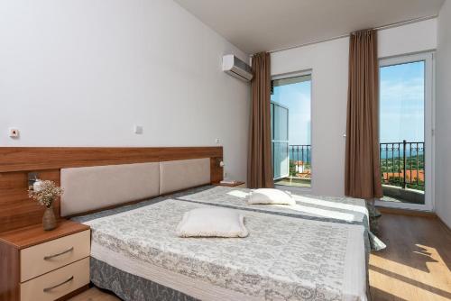 sypialnia z dużym łóżkiem i dużym oknem w obiekcie Villa Entre w mieście Emona