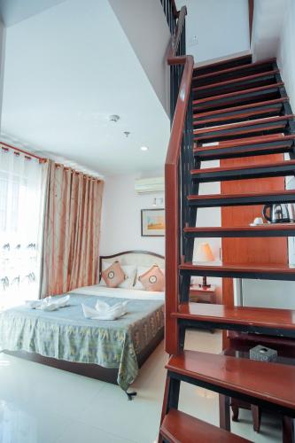 a bedroom with a bed and a staircase at Silver Mounts Hotel in Phnom Penh