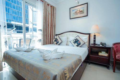 a bedroom with a bed and a large window at Silver Mounts Hotel in Phnom Penh