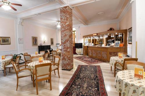 モンテカティーニ・テルメにあるHotel Brennero e Varsaviaのテーブルと椅子のあるレストラン、バー