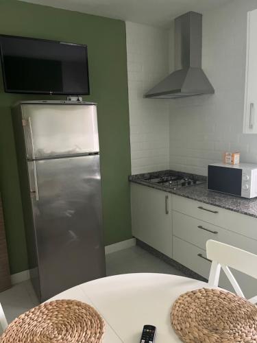 uma cozinha com um frigorífico de aço inoxidável e um micro-ondas em Viviendas uso turístico REME II em Foz