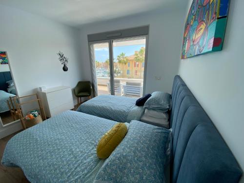 1 dormitorio con 2 camas, sofá y ventana en La Marina Sotogrande Pier2, en Torreguadiaro