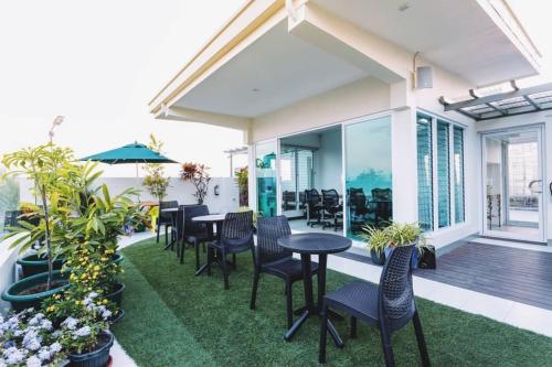 un patio con sedie e tavoli su un balcone di H Plus Hotel powered by Cocotel a Manila