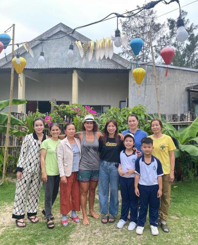 a group of people posing for a picture in front of a house at Ngoc An Bang Villa in An Bang