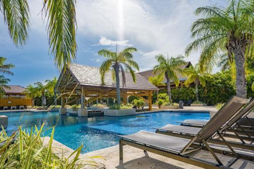 a swimming pool with two lounge chairs and palm trees at Laguna Lake House - Private Pool - Sleeps 12 - Elegant in Playa Blanca