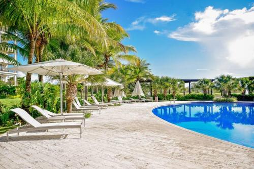a pool with chaise lounge chairs and an umbrella at Laguna Lake House - Private Pool - Sleeps 12 - Elegant in Playa Blanca