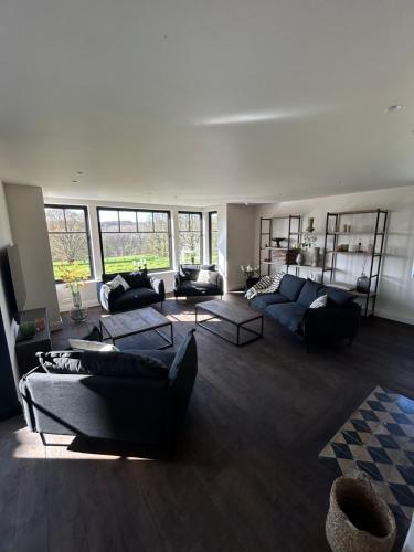 a large living room with couches and tables at Vakantiehuis Muziekbos - 20 personen in Ronse
