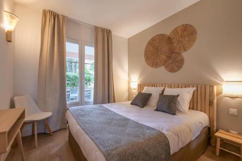 une chambre avec un lit, un bureau et une fenêtre dans l'établissement Brise Marine piscine St Tropez II, à Saint-Tropez